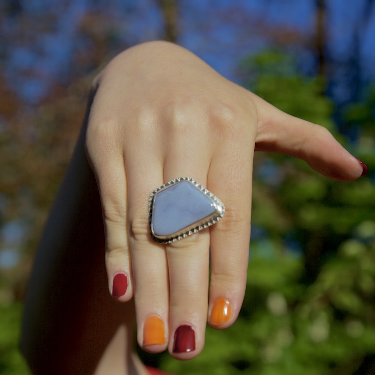 forget me not blue ring with large chalcedony stone set in silver on hand