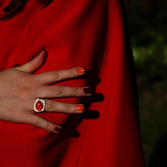 Orange gemstone carnelian ring worn on model, the colour of marigolds